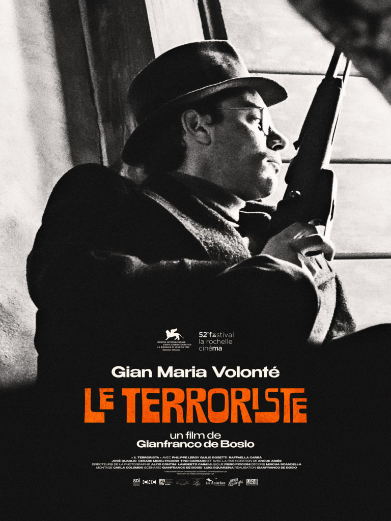 Affiche en noir et blanc du film "Le Terroriste". Un homme en chapeau et manteau sombre, tenant un fusil, est photographié en contre-plongée près d’une fenêtre. Il s’agit de l’acteur Gian Maria Volonté. Le titre du film, "Le Terroriste", est inscrit en grandes lettres capitales orange au centre, suivi de la mention "un film de Gianfranco de Bosio". En haut, le logo de la Mostra de Venise et celui du Festival La Rochelle Cinéma sont visibles. En bas de l’affiche figurent les crédits de production et les logos des partenaires.